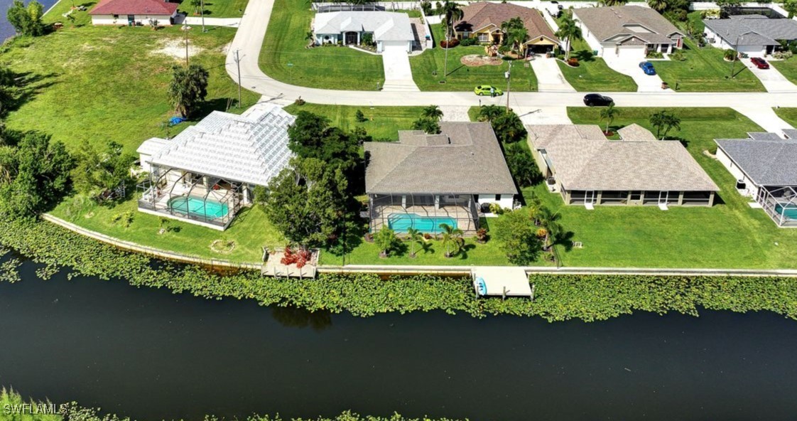 an aerial view of a house with swimming pool patio and lake view