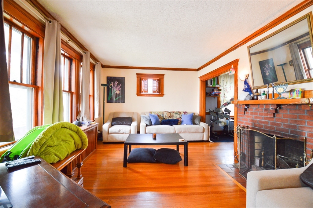 a living room with fireplace furniture and a large window