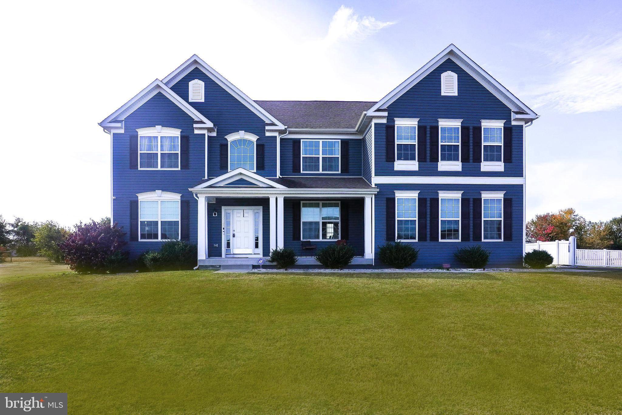 a front view of a house with a yard and trees