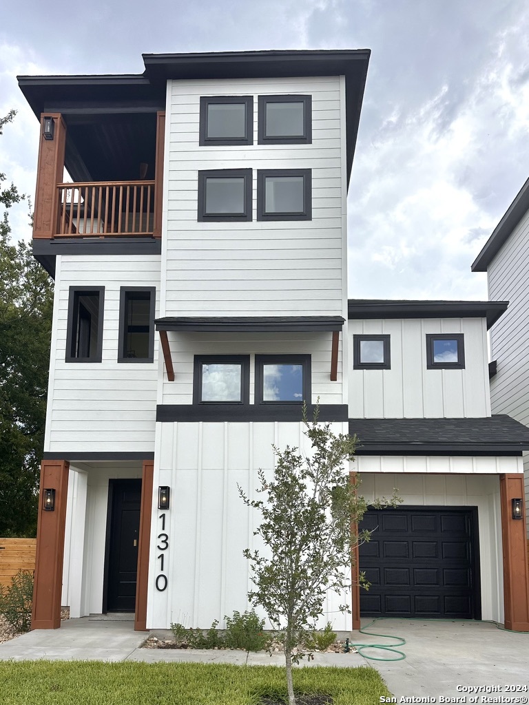 a front view of a house with yard and parking