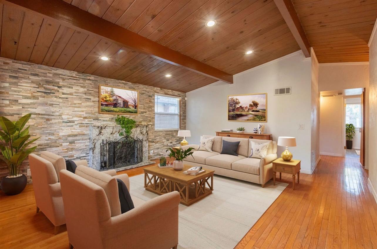 a living room with furniture wooden floor and a potted plant