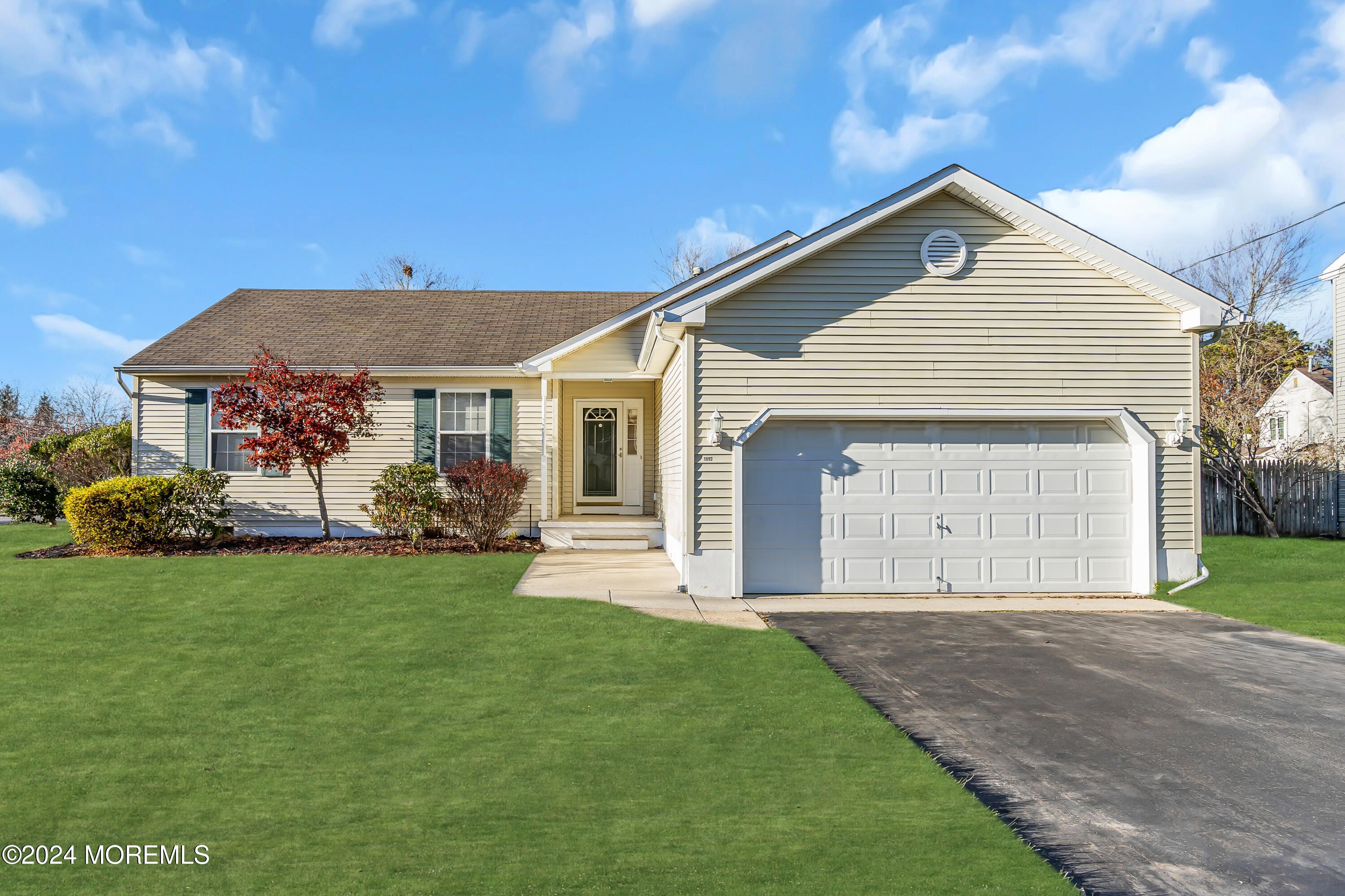 a front view of a house with a garden and yard