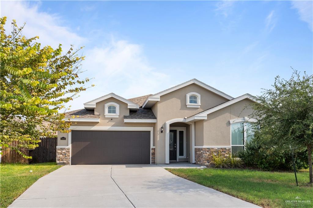 a front view of a house with a yard and garage