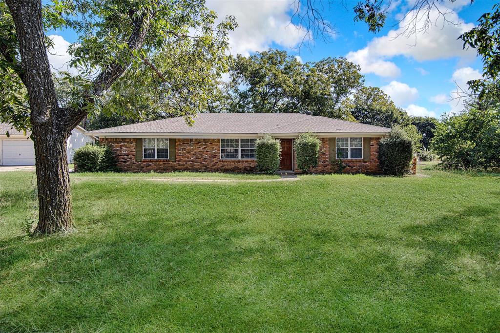 a view of a house with a big yard and large trees