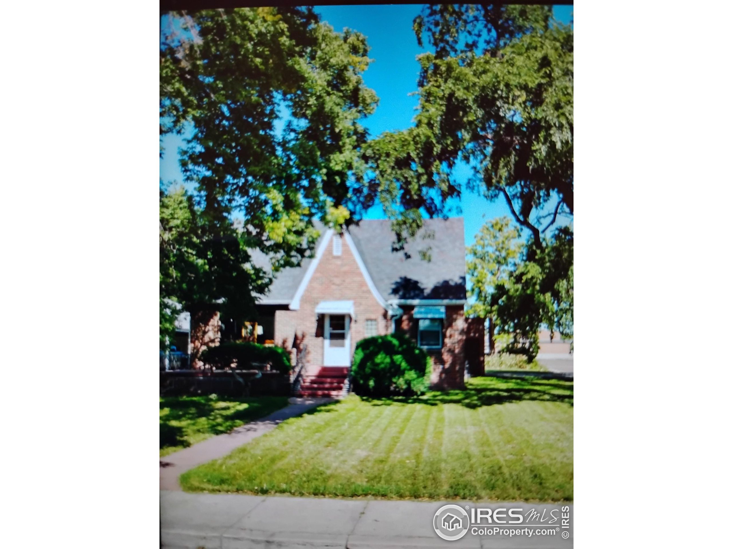 a view of a house with a yard and potted plants