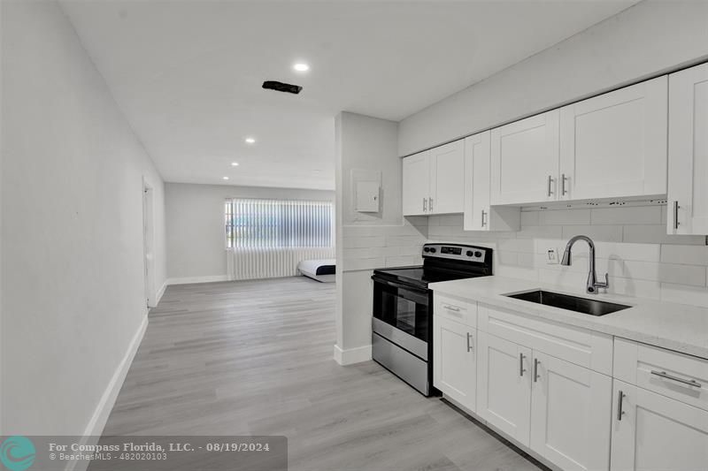 a kitchen with granite countertop white cabinets and white appliances