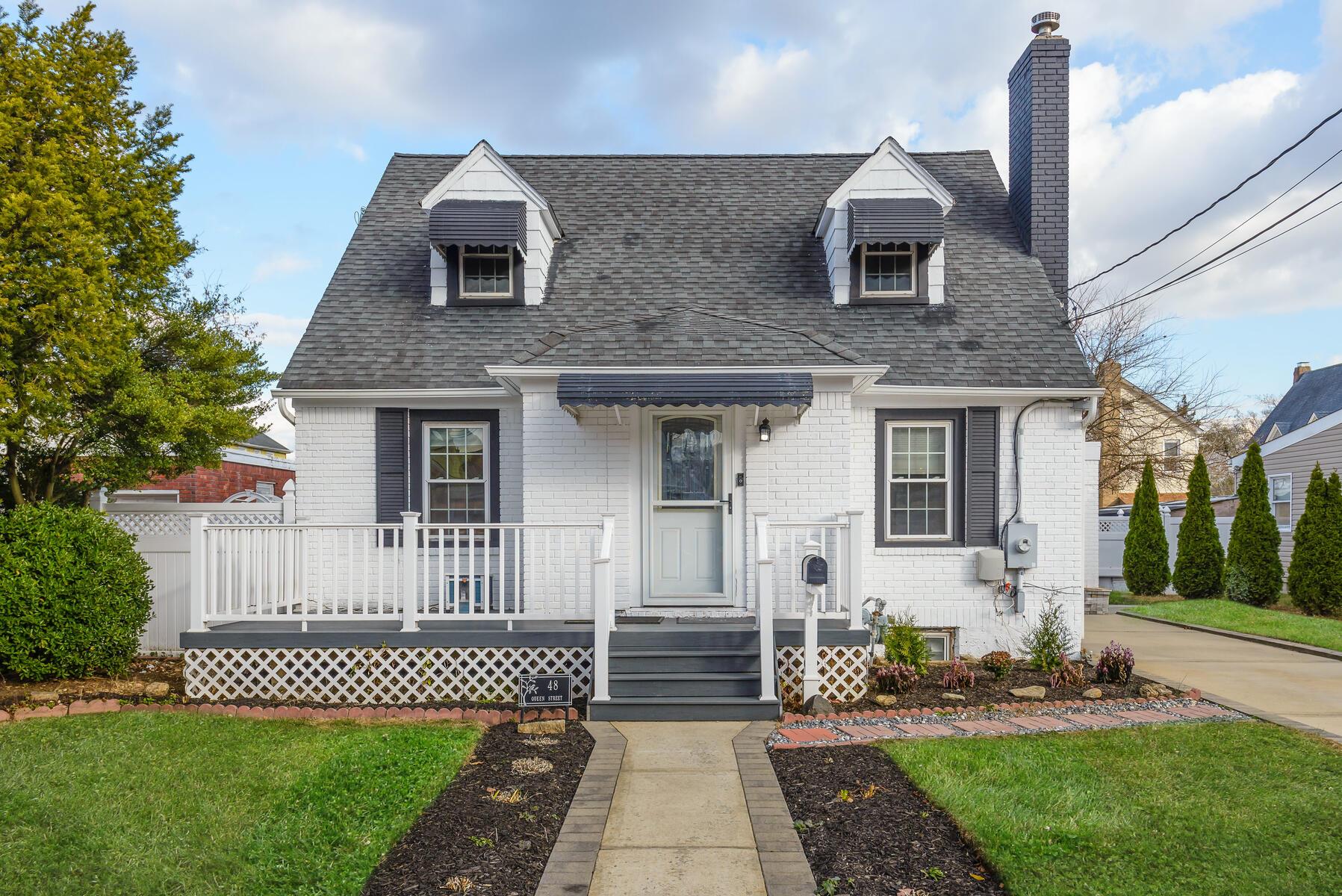 New england style home featuring a front yard