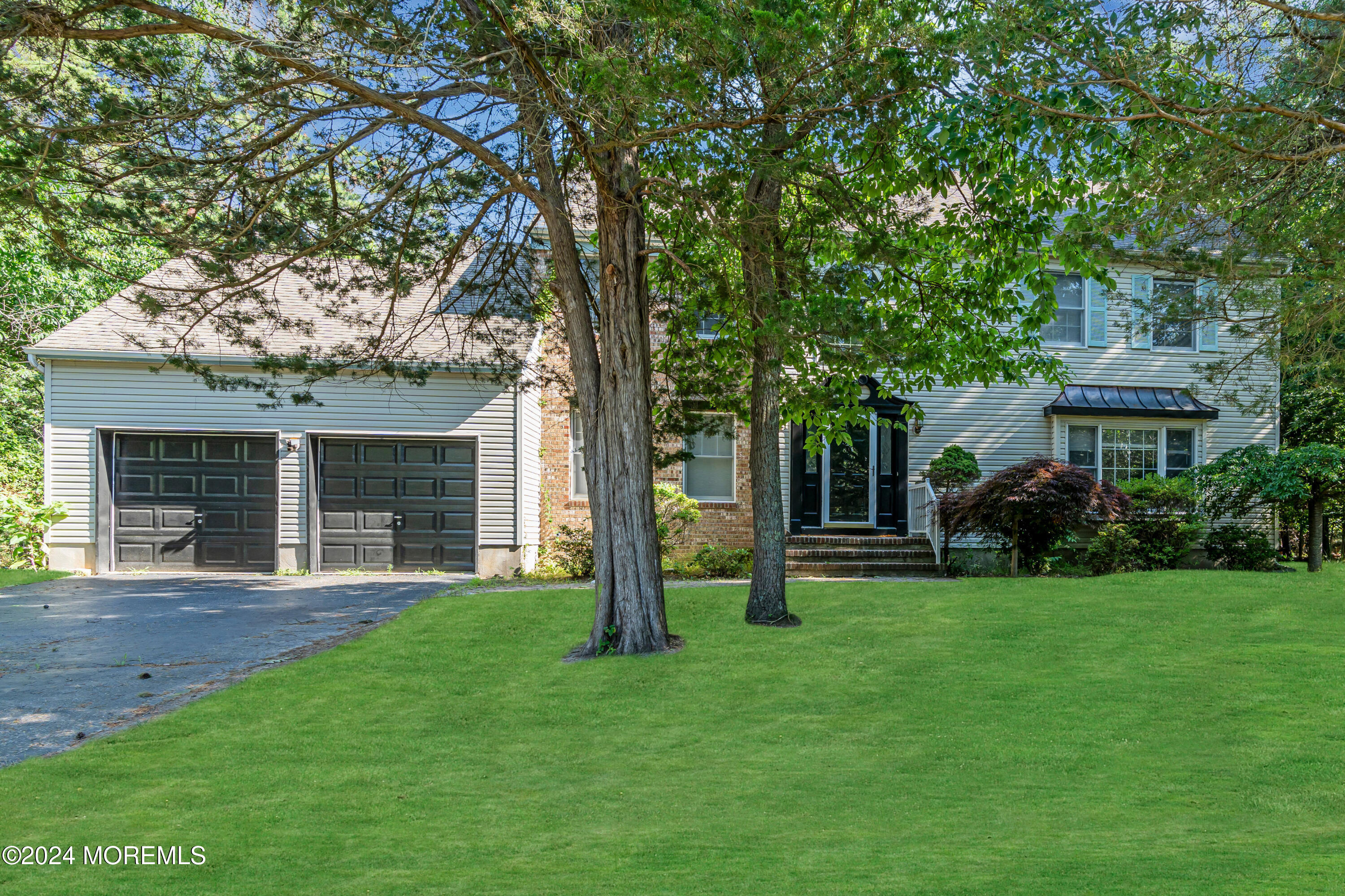 a front view of a house with a yard and trees