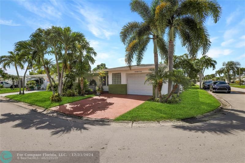 a couple of palm trees in front of yellow house