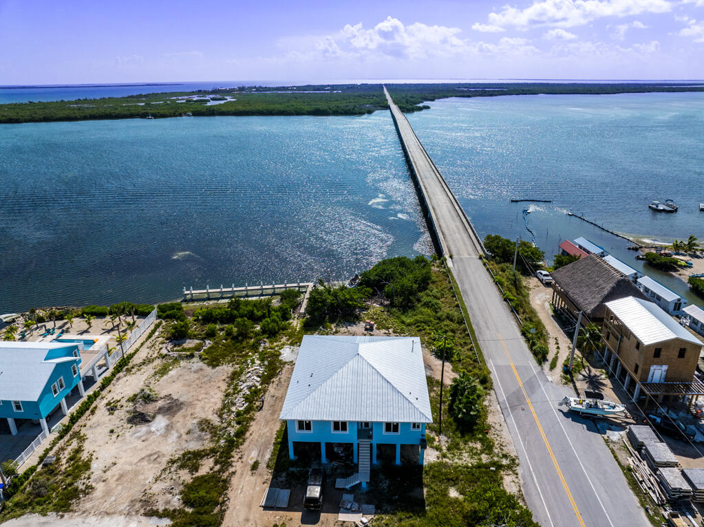 an aerial view of a house with a lake and palm trees