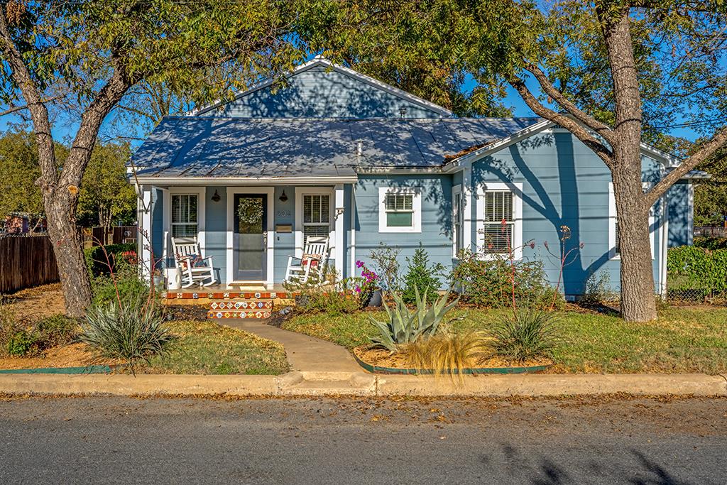 a front view of a house with a yard and potted plants