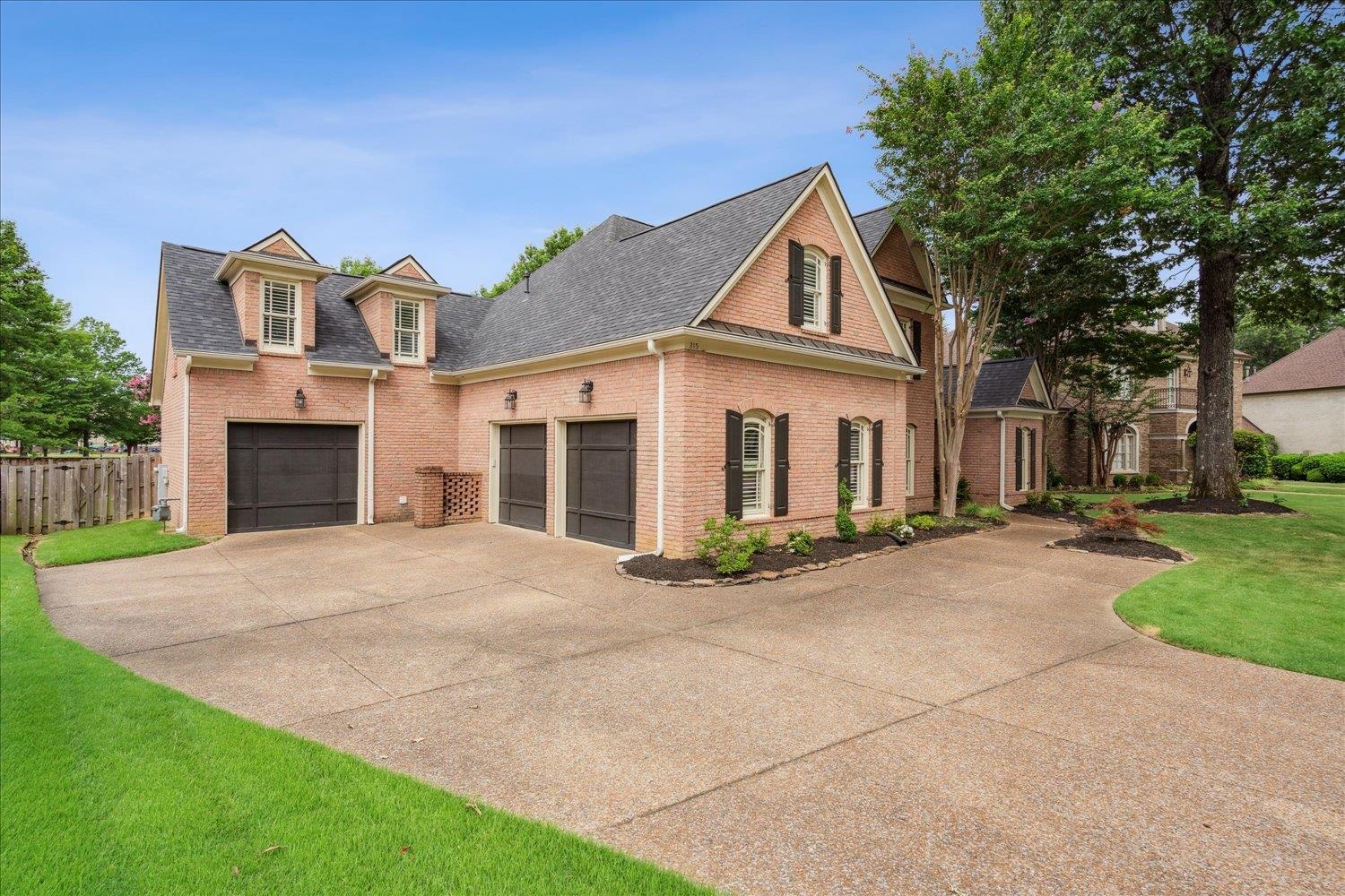 a front view of a house with yard and parking