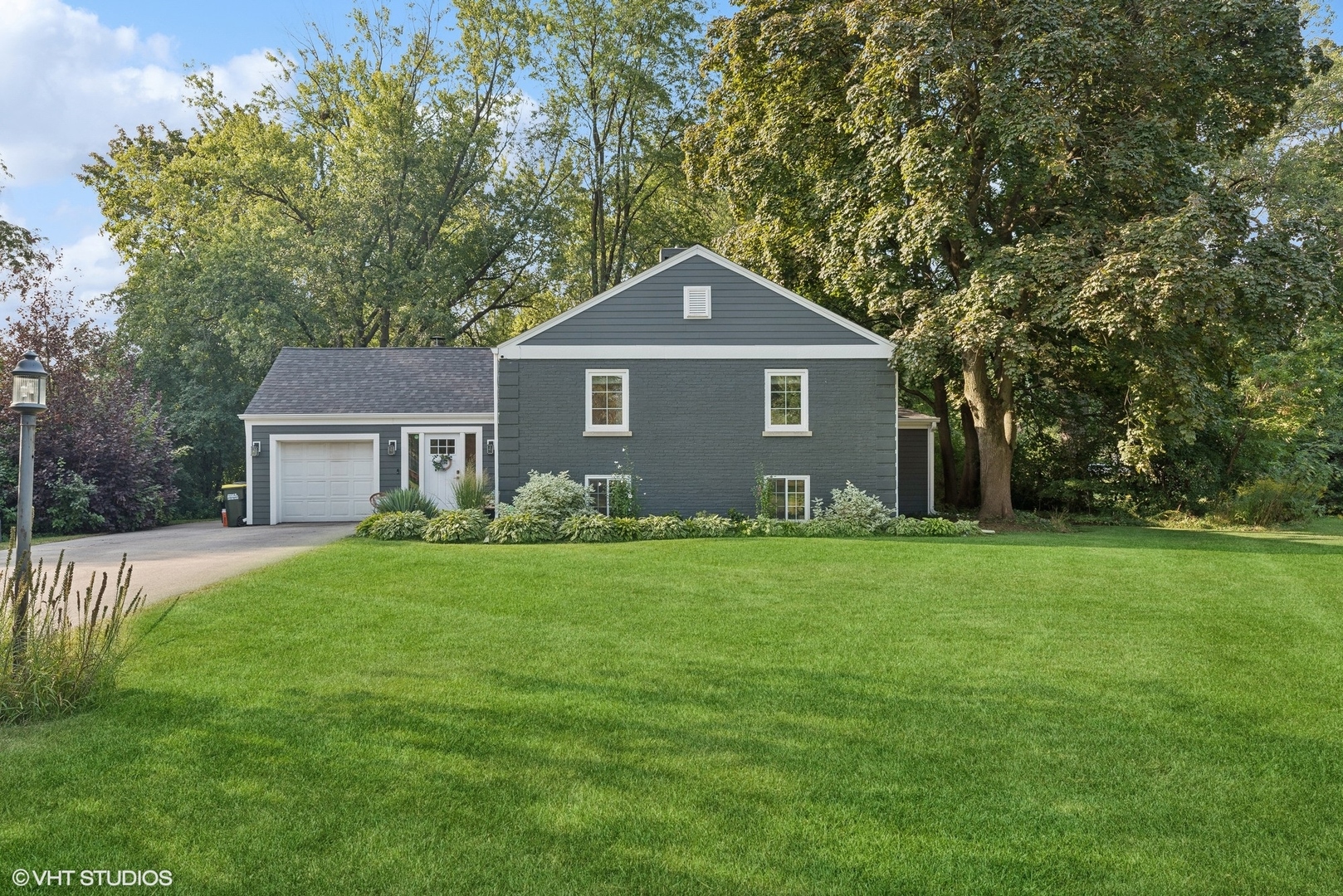 a front view of a house with yard and green space