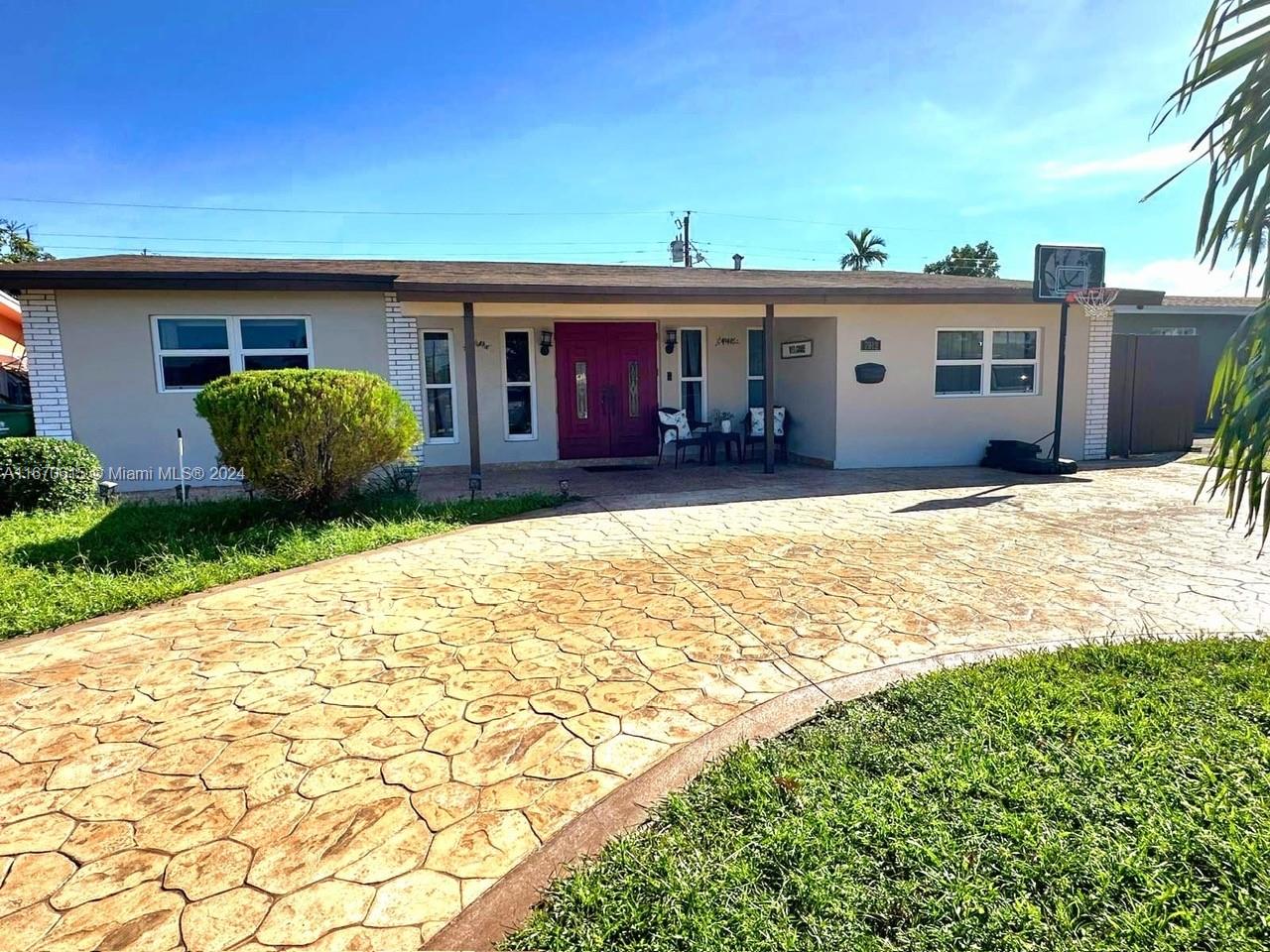 a view of a house with floor to ceiling windows and a yard