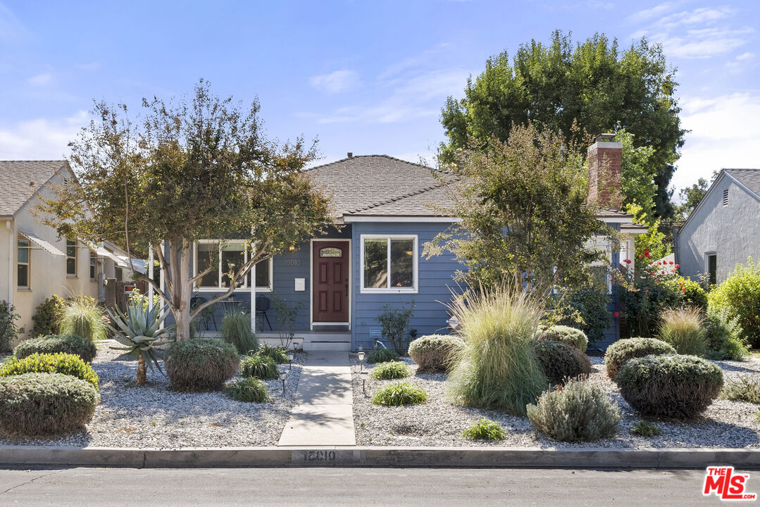 a view of a house with a yard and potted plants