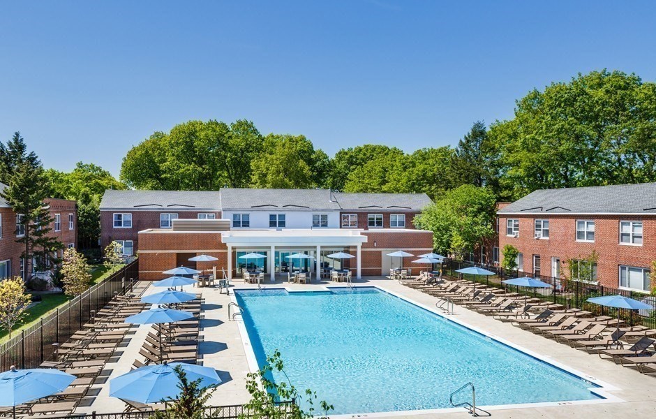 an aerial view of a house with swimming pool and red chairs