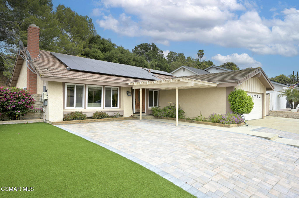 a front view of a house with a garden and patio