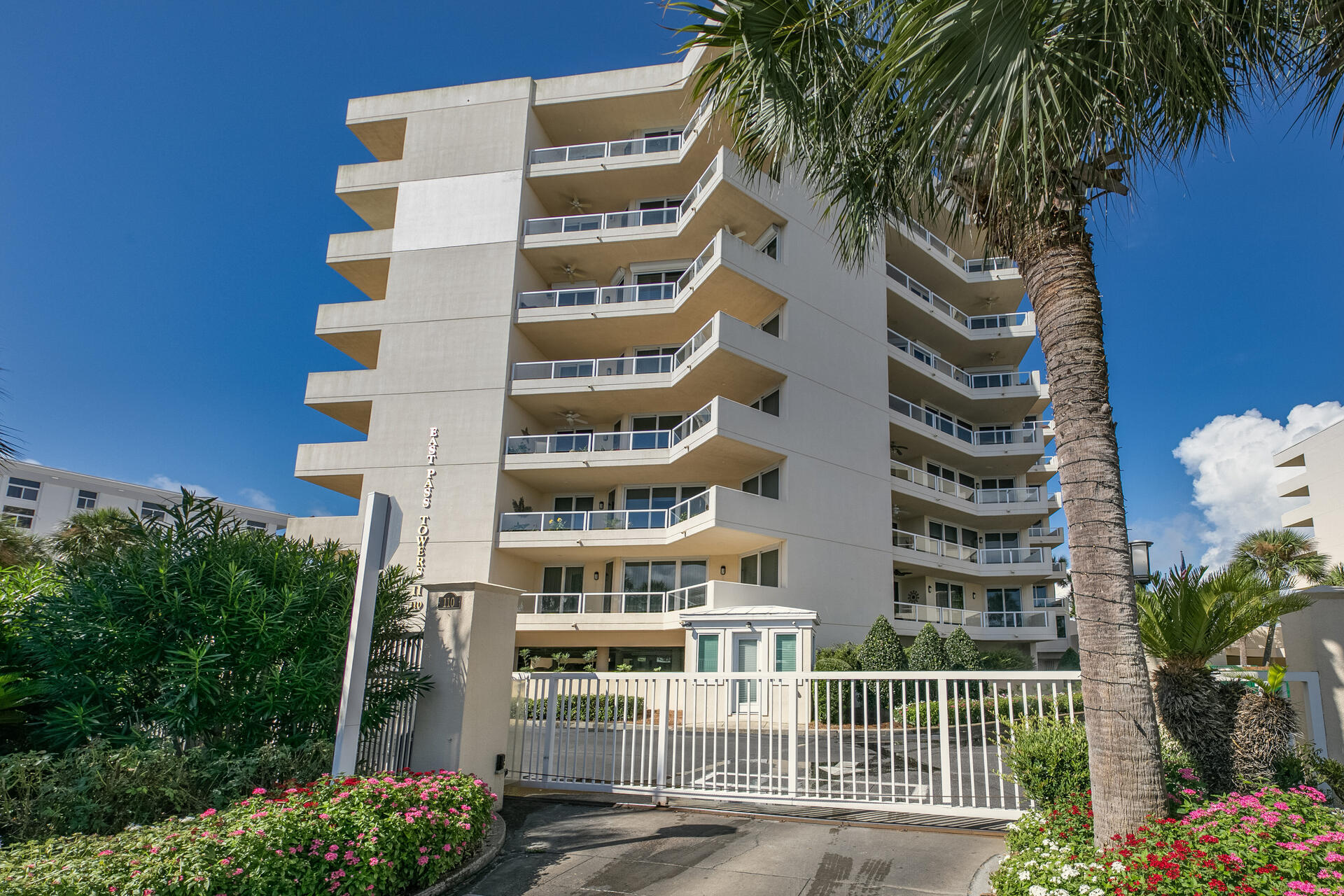 a front view of multi story residential apartment building with yard and entryway