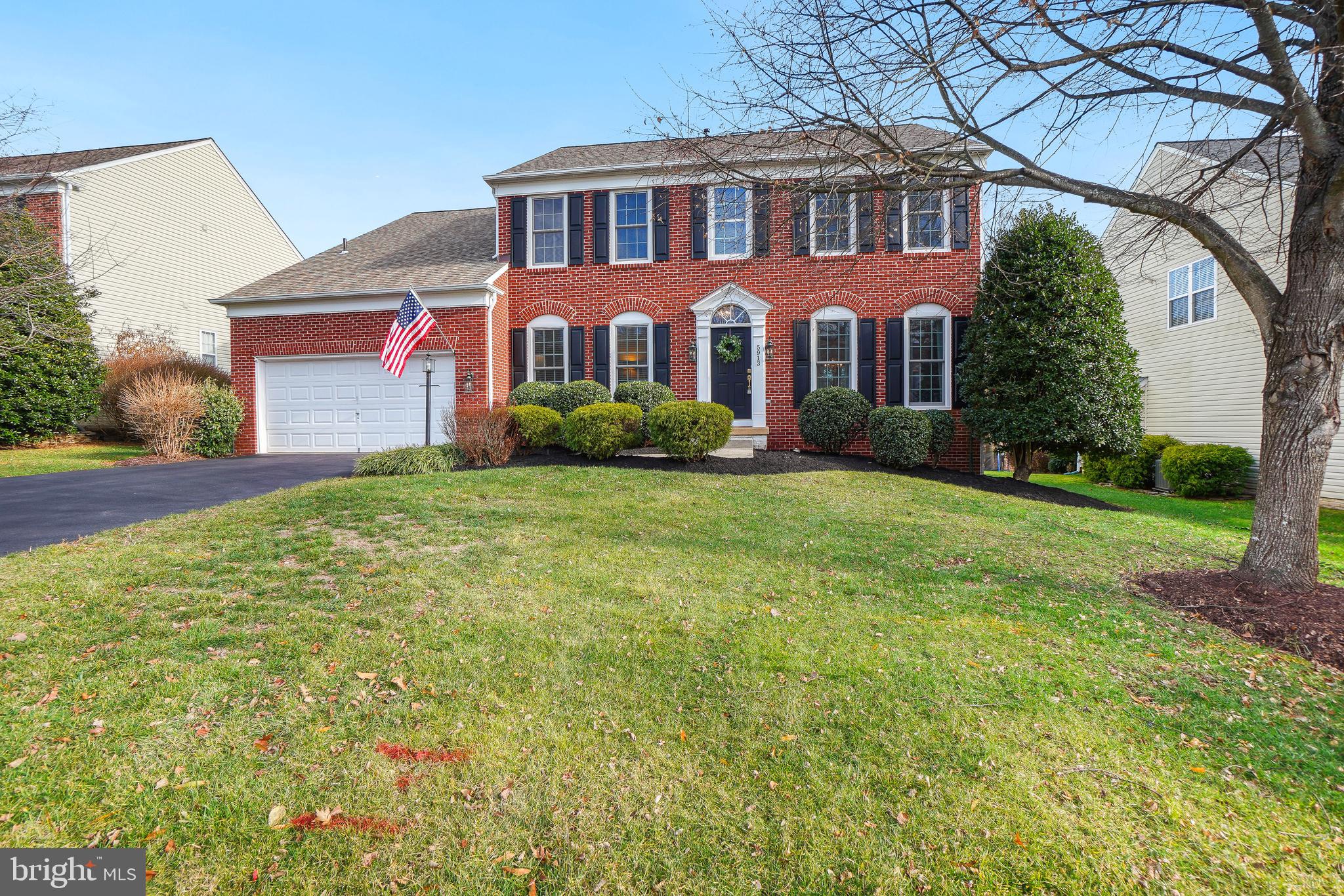 a front view of a house with yard and green space