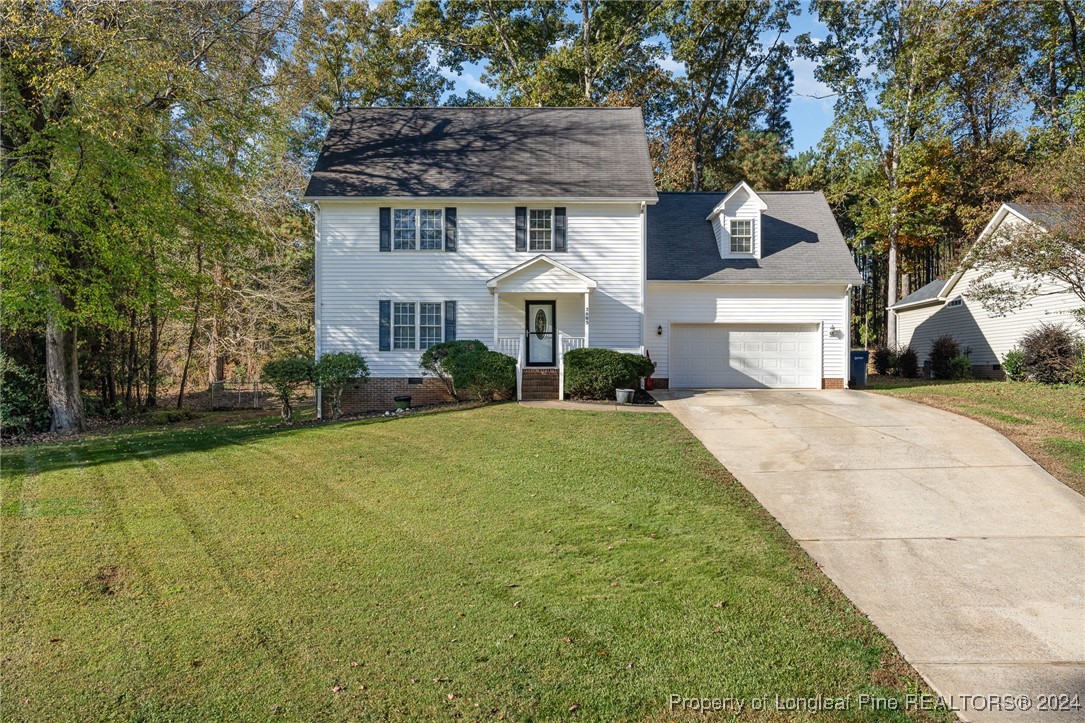 a front view of a house with a yard and trees