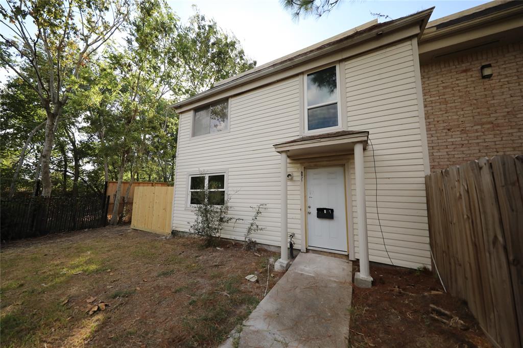 a view of a house with backyard and trees