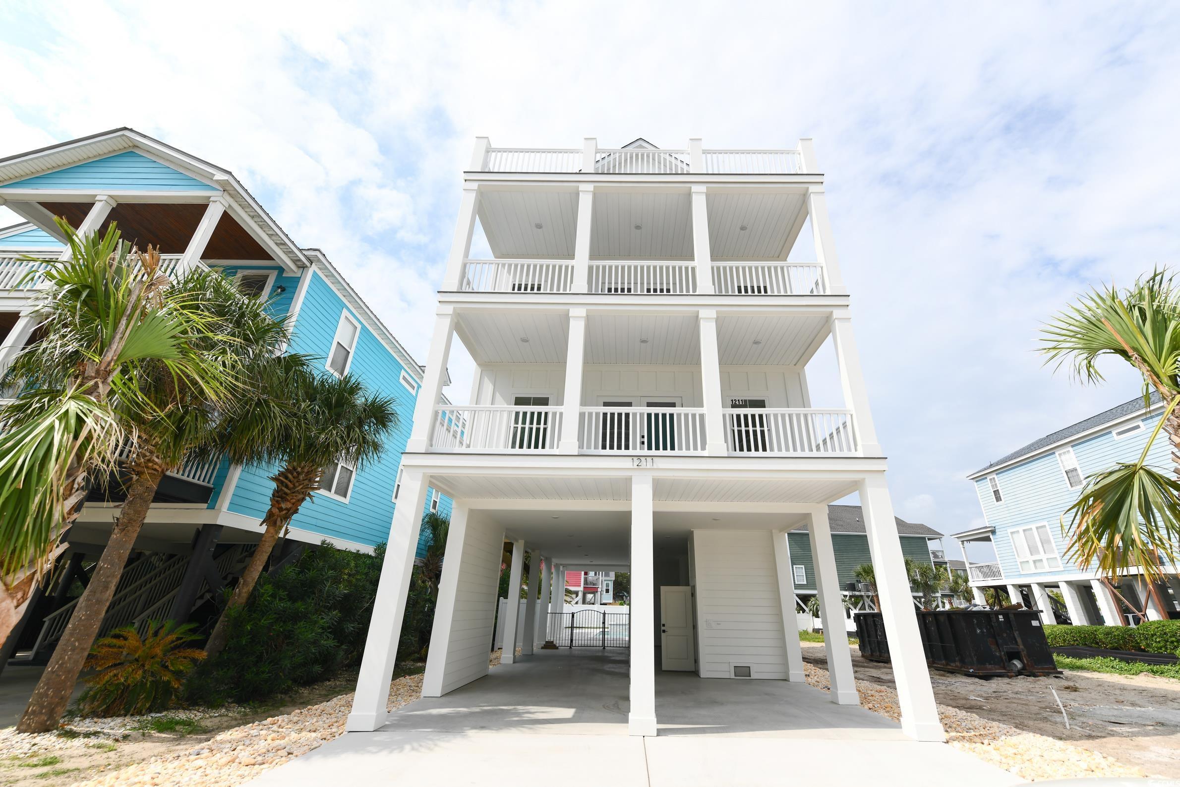 View of front of house with a balcony and a carpor