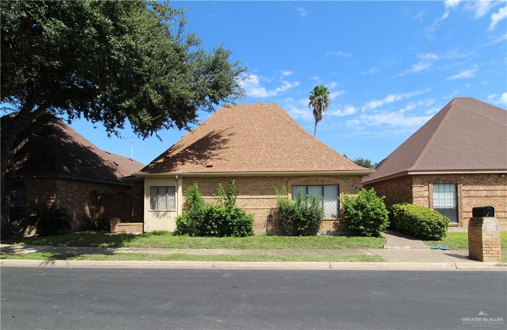 a front view of a house with a yard and potted plants