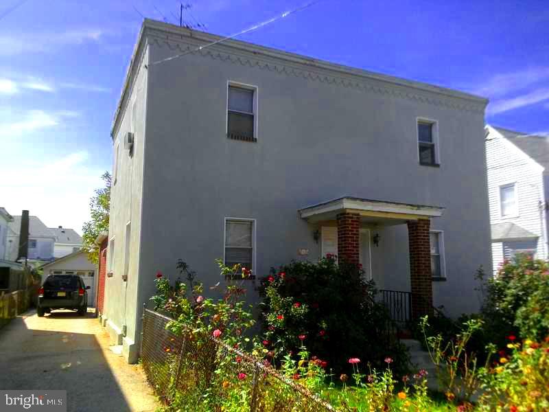 a front view of house and yard with beautiful flowers