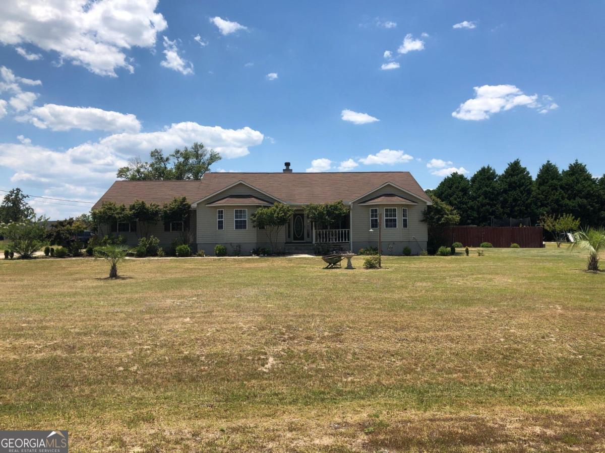 a front view of house with yard swimming pool and outdoor seating