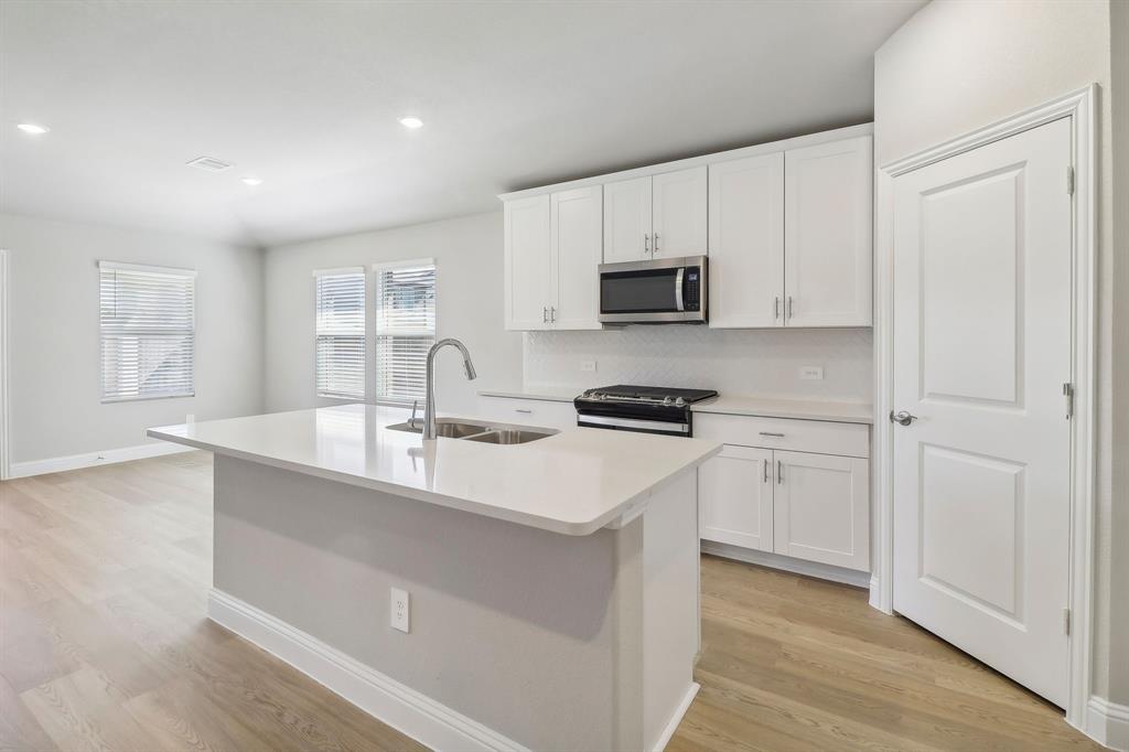 a kitchen with stainless steel appliances a sink stove and cabinets