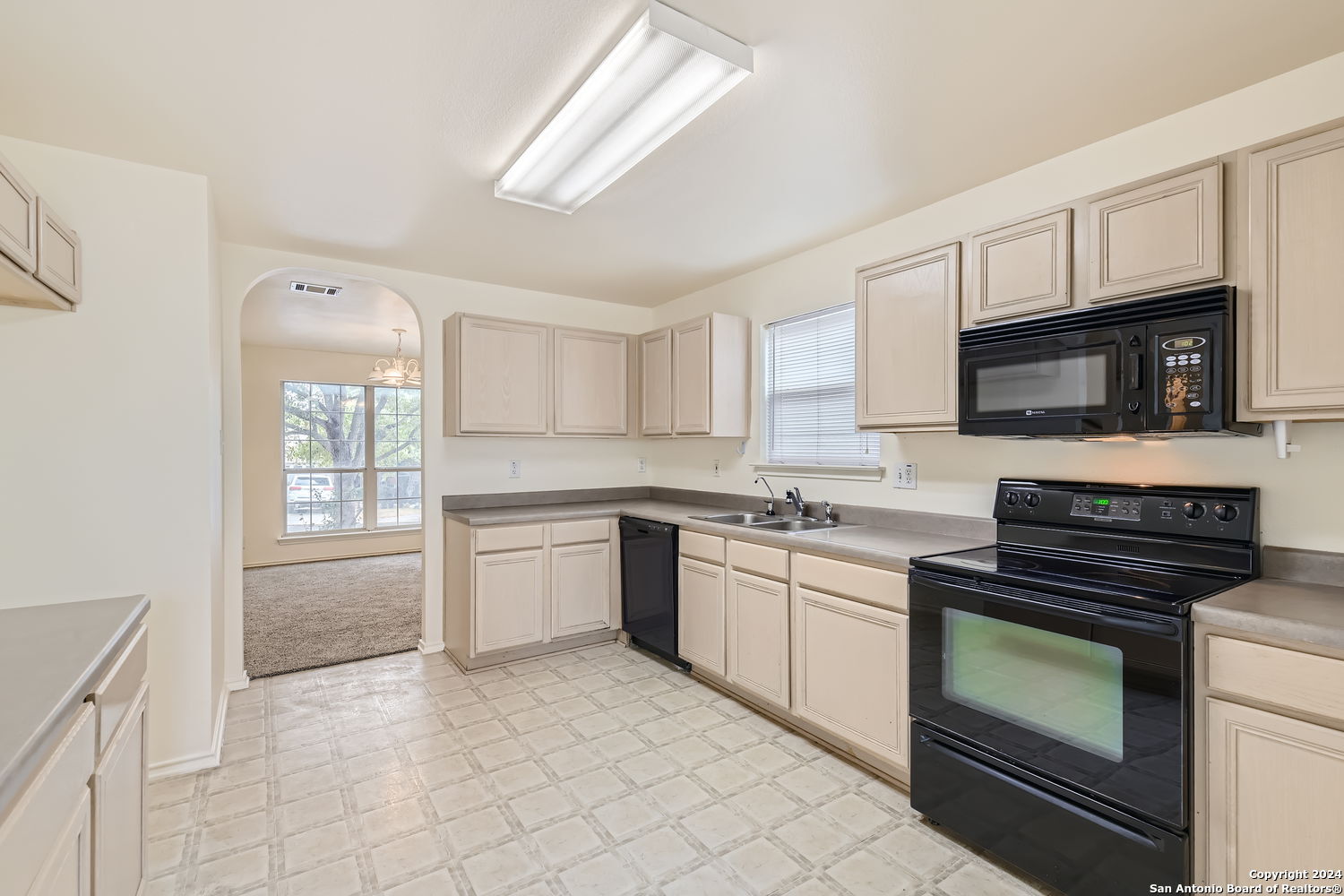 a kitchen with granite countertop a stove sink and microwave