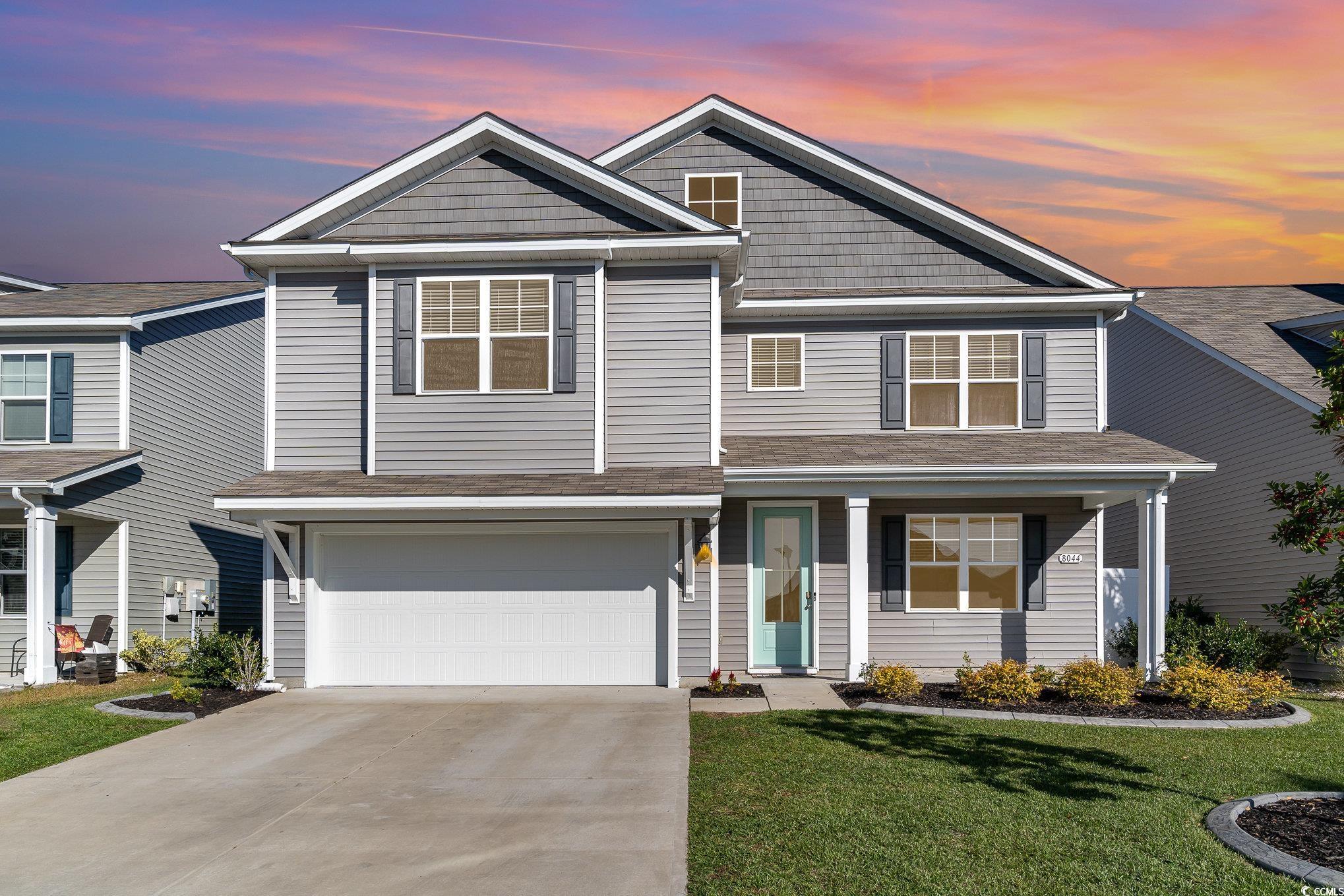 View of front of house featuring a yard and a gara