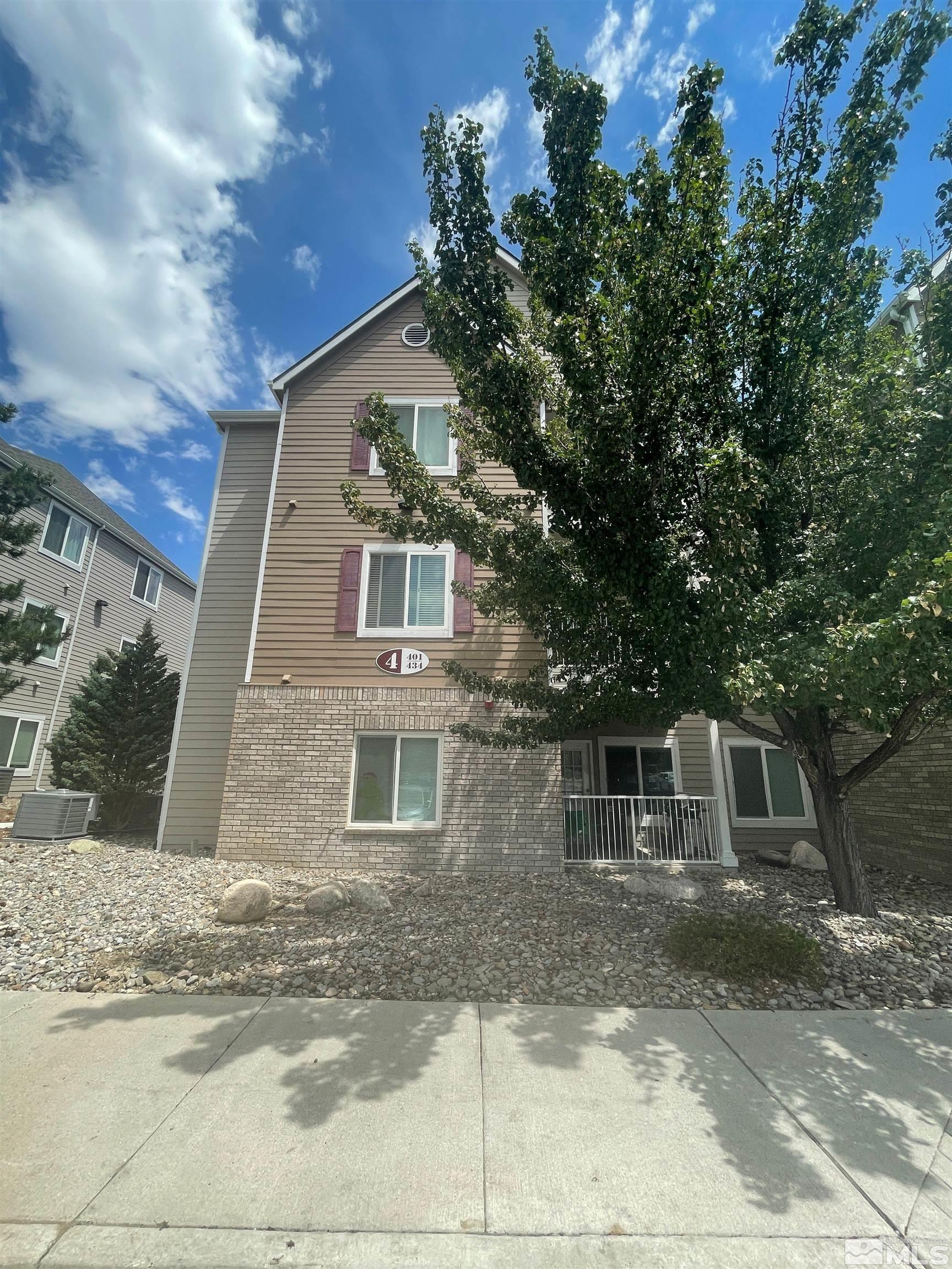 a front view of a house with a tree