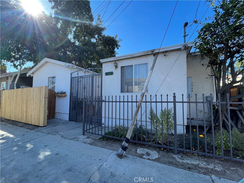 a backyard of a house with plants and trees with wooden fence