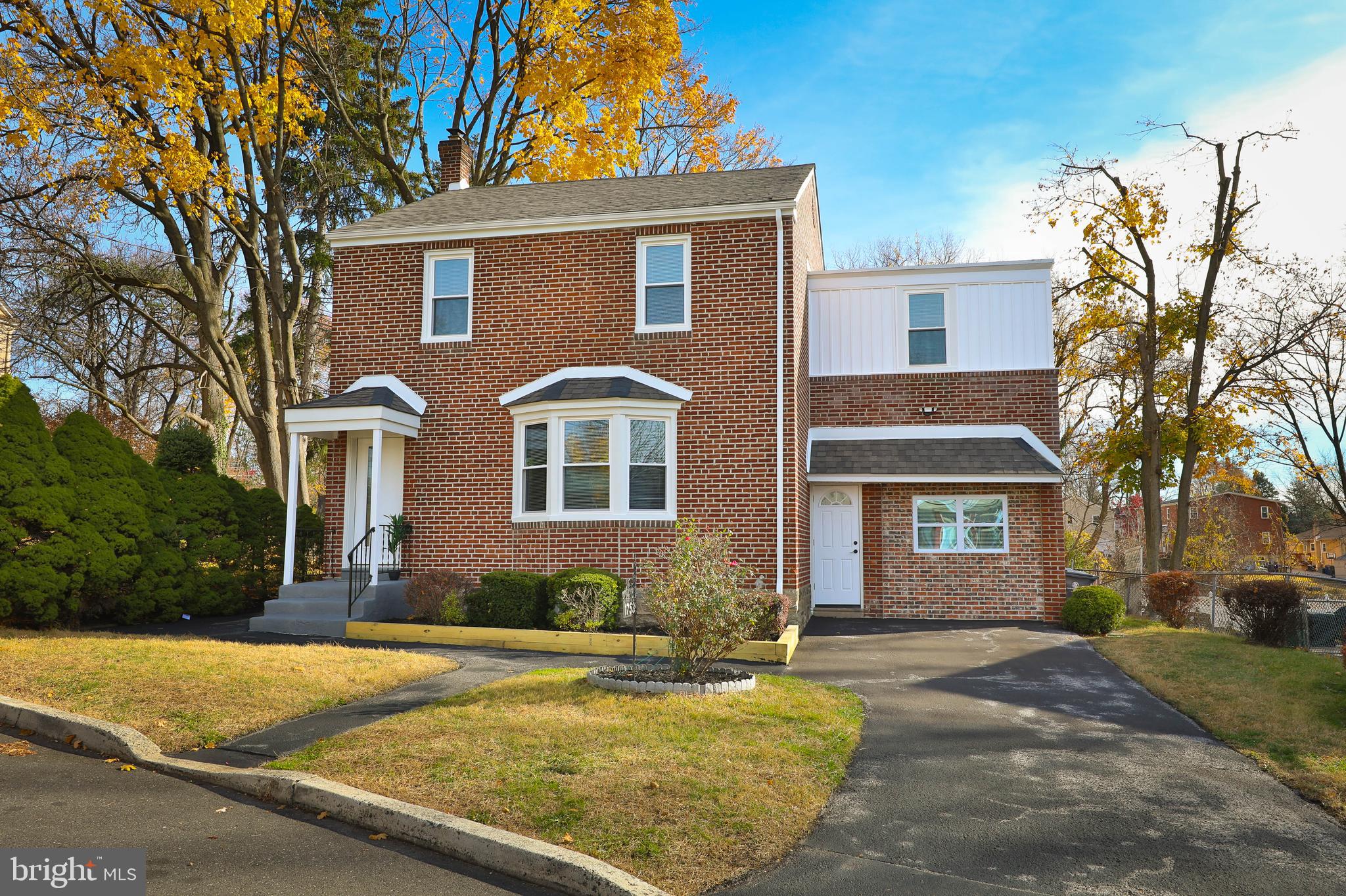 a front view of a house with yard and trees