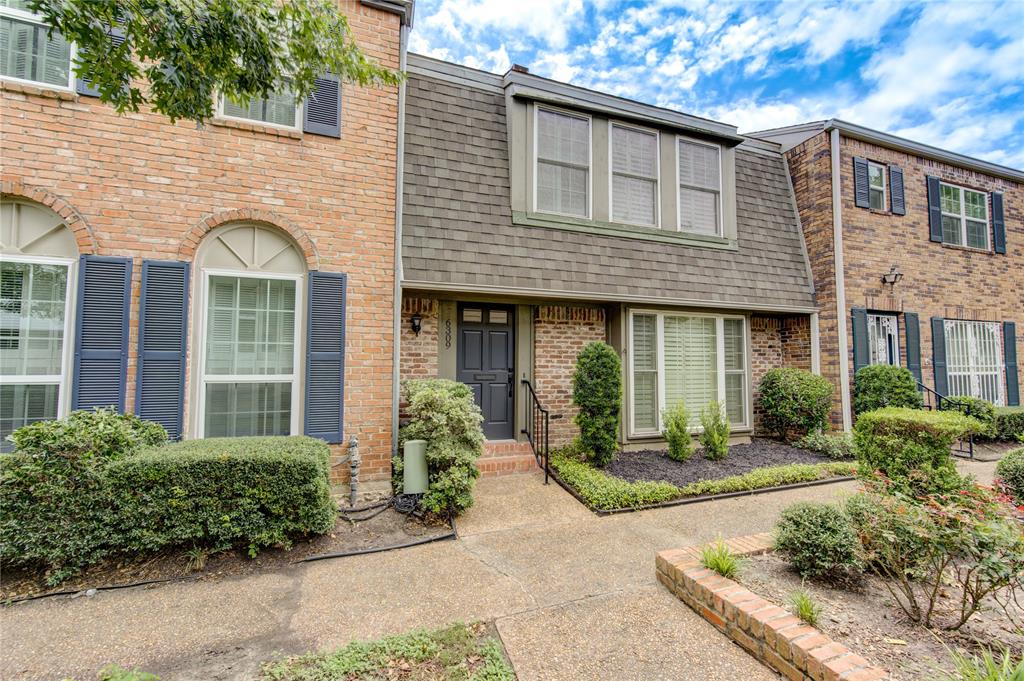 front view of a brick house with a small yard