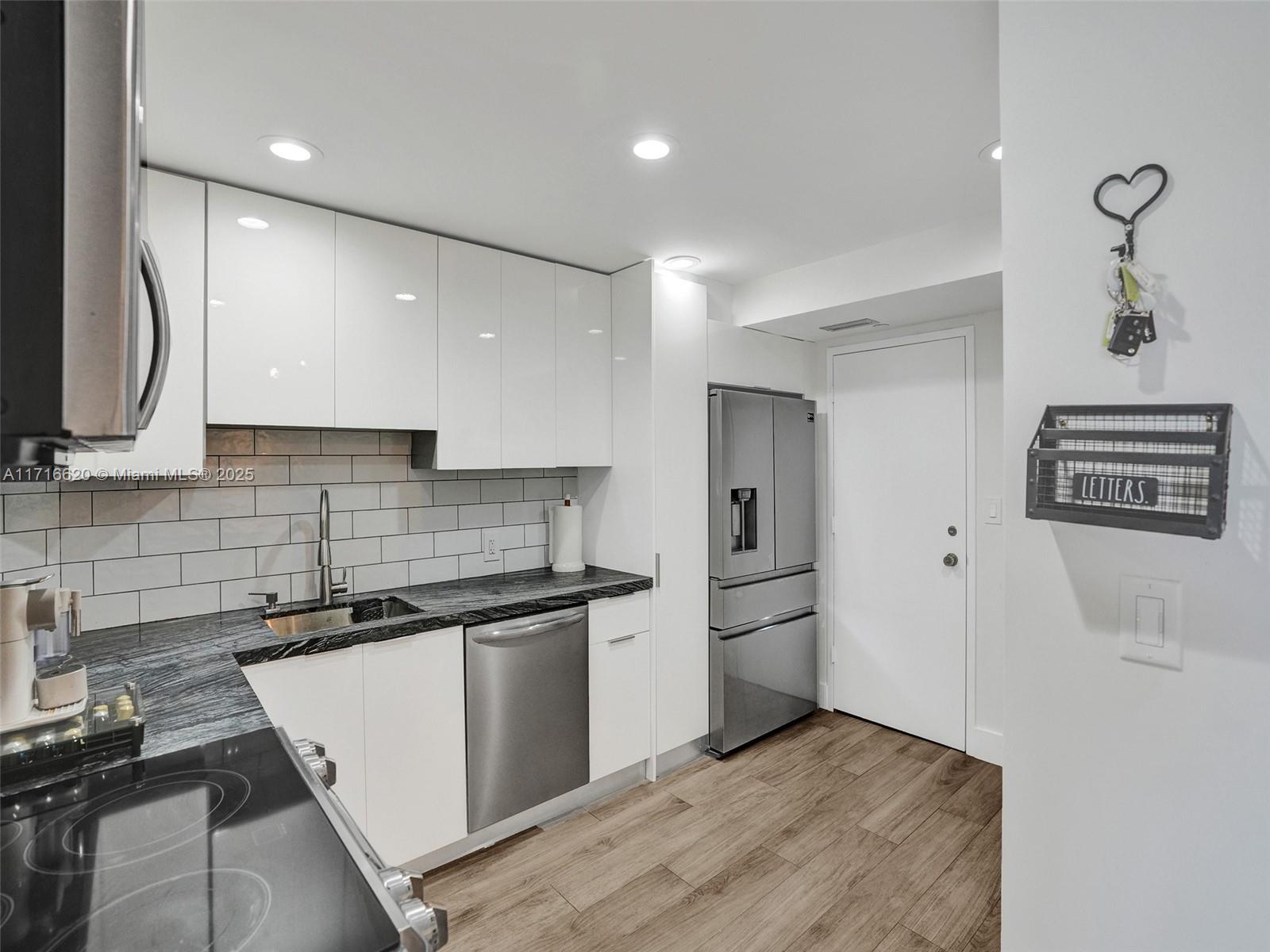 a kitchen with granite countertop a sink and stainless steel appliances