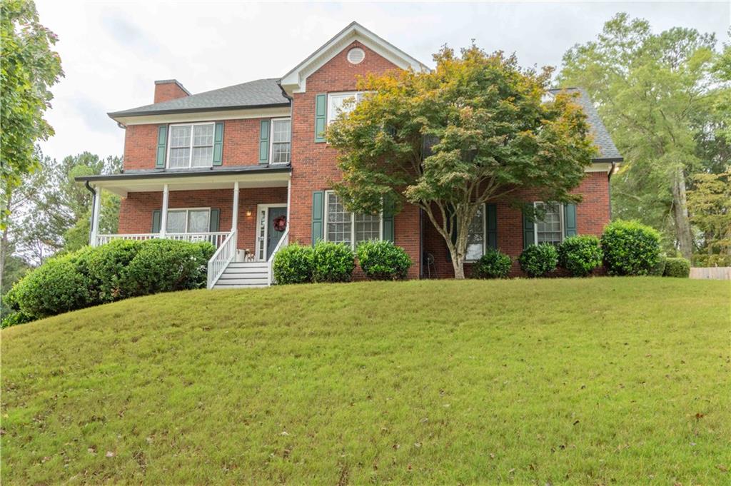 a front view of house with yard and green space