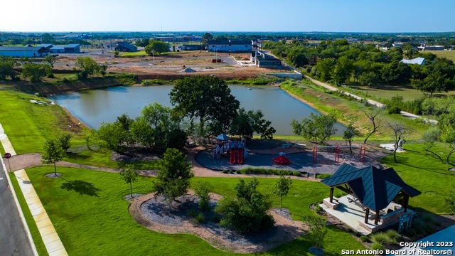 an aerial view of residential houses with outdoor space and lake view