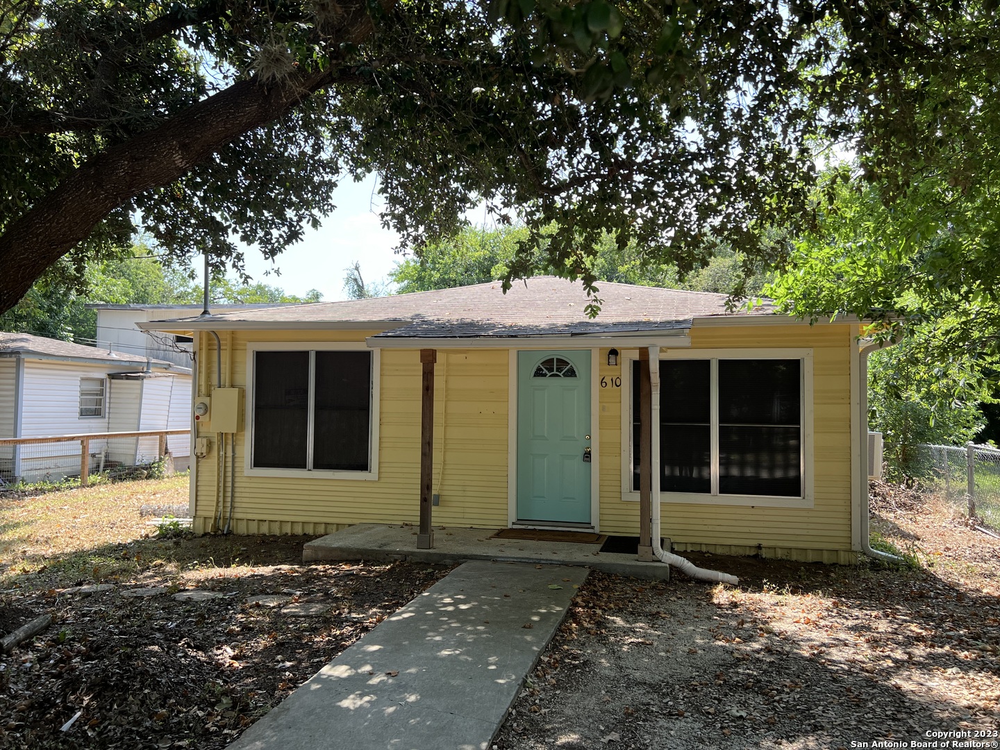 a front view of a house with a tree