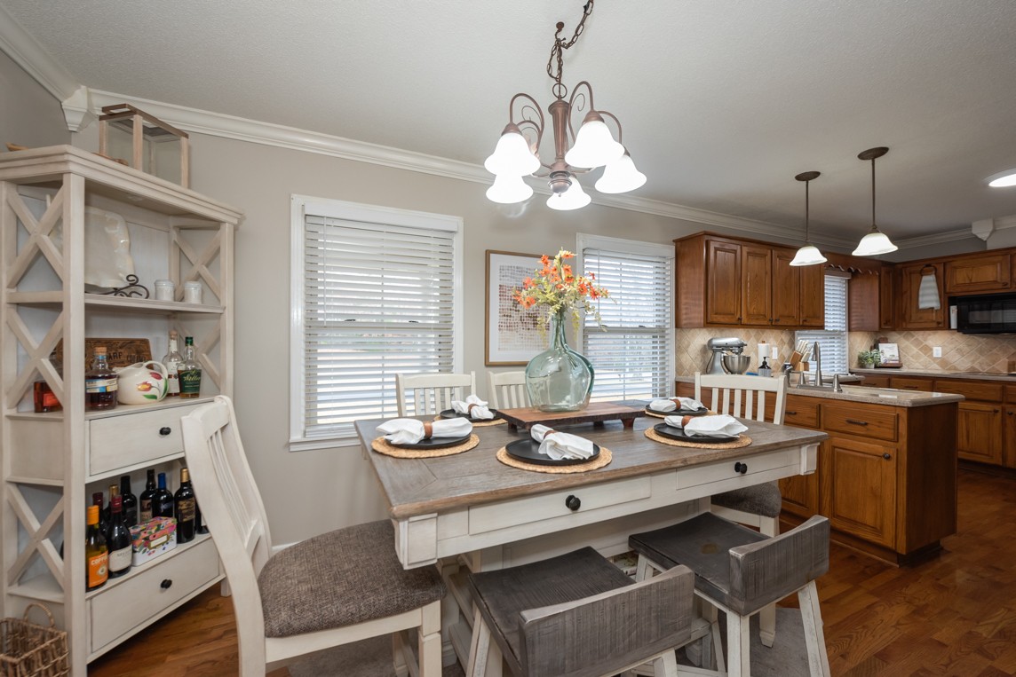 a view of a dining room with furniture a chandelier and wooden floor