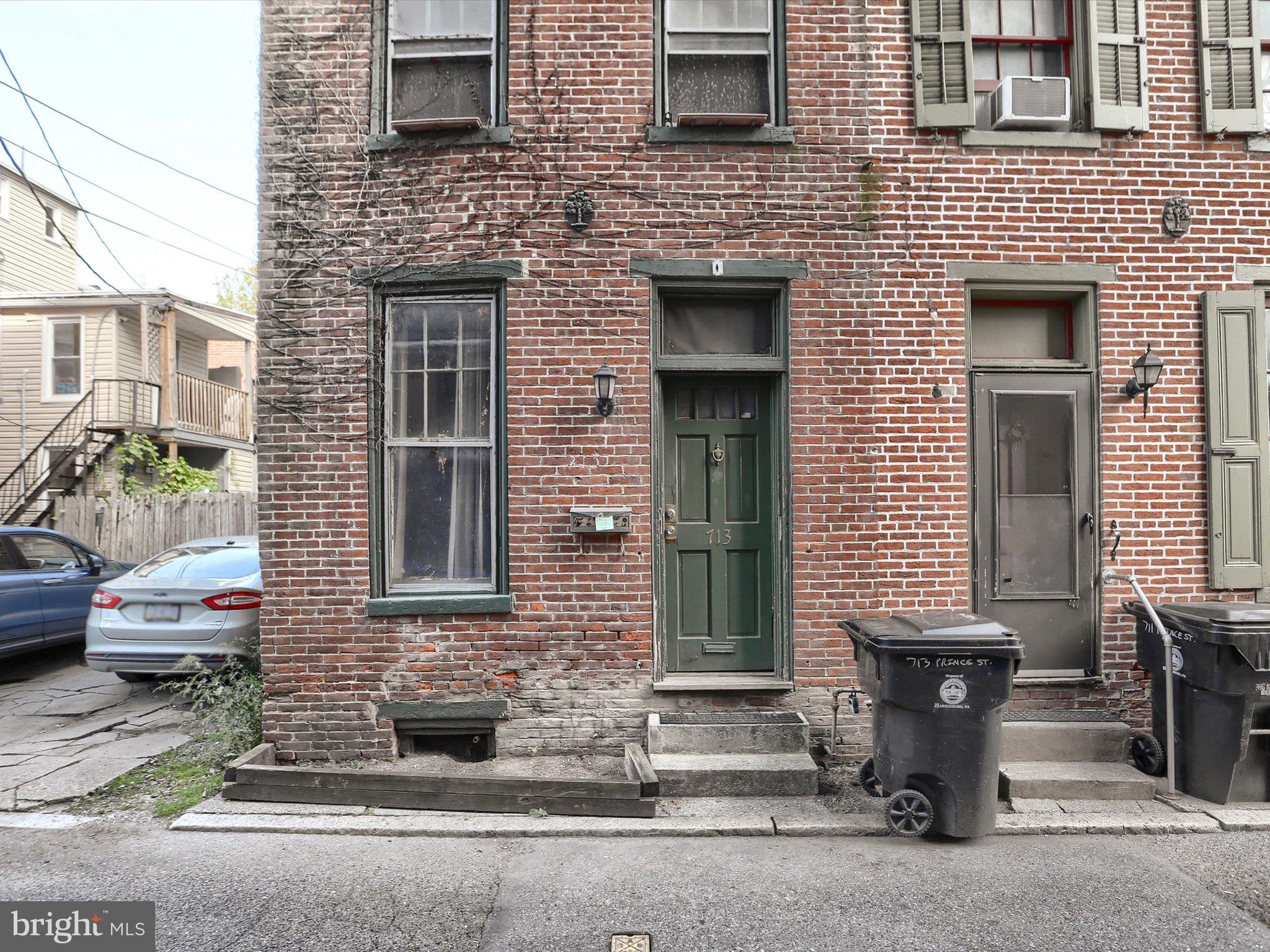 a brick house with a bench next to a road