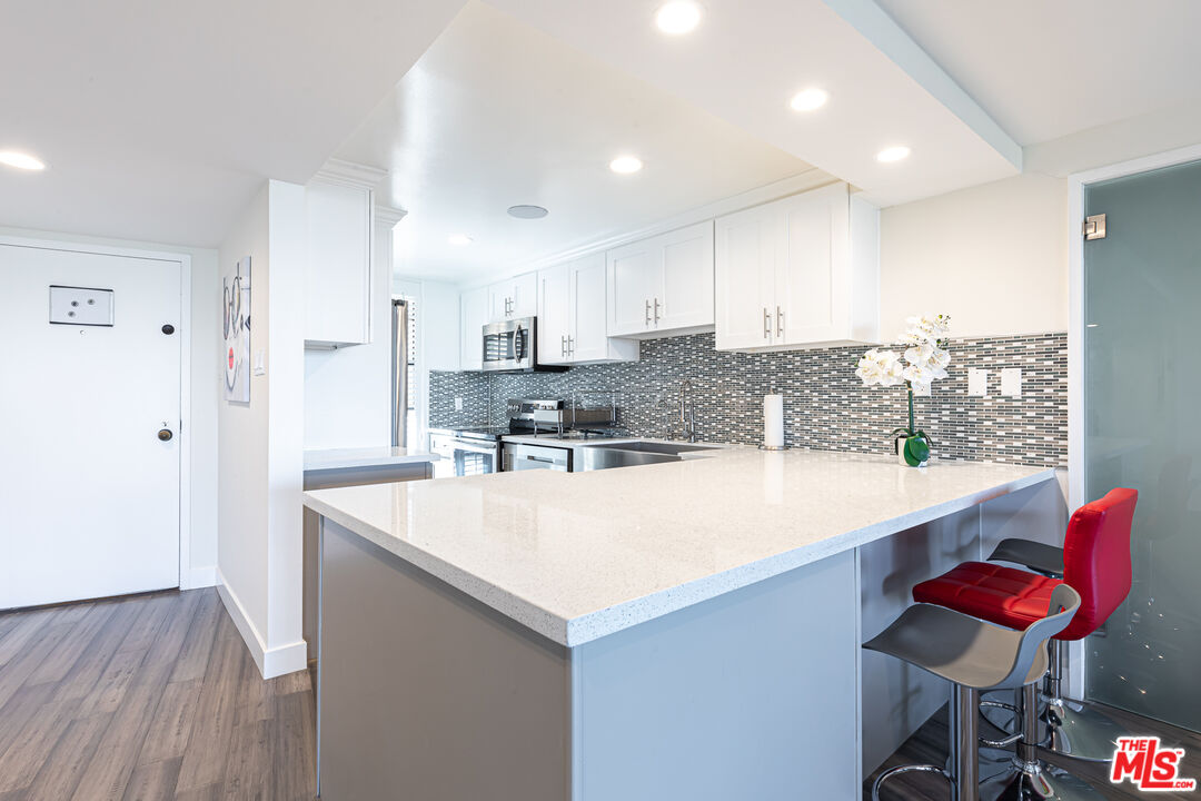 a large kitchen with kitchen island a sink table and chairs