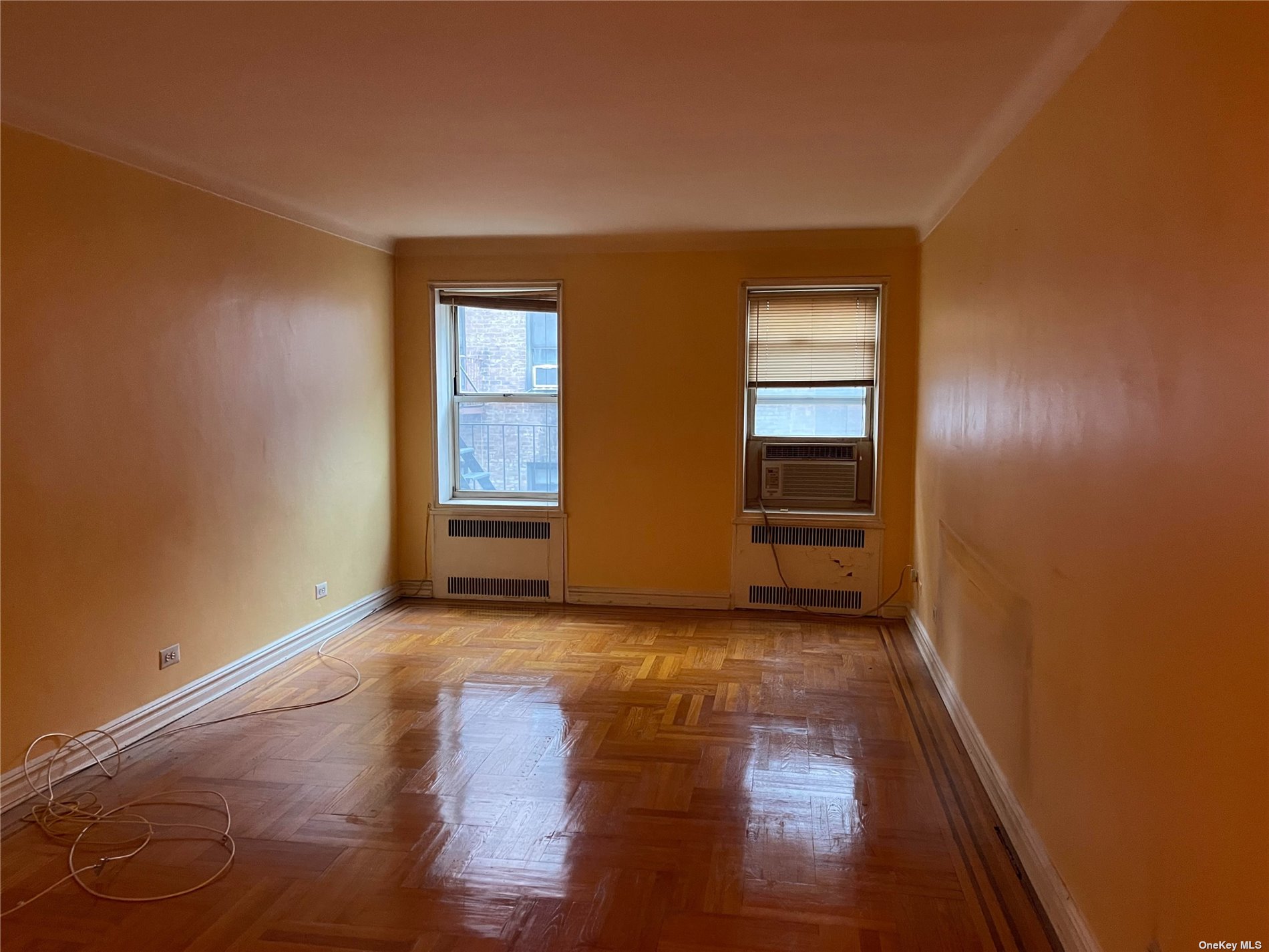 a view of an empty room with wooden floor and closet