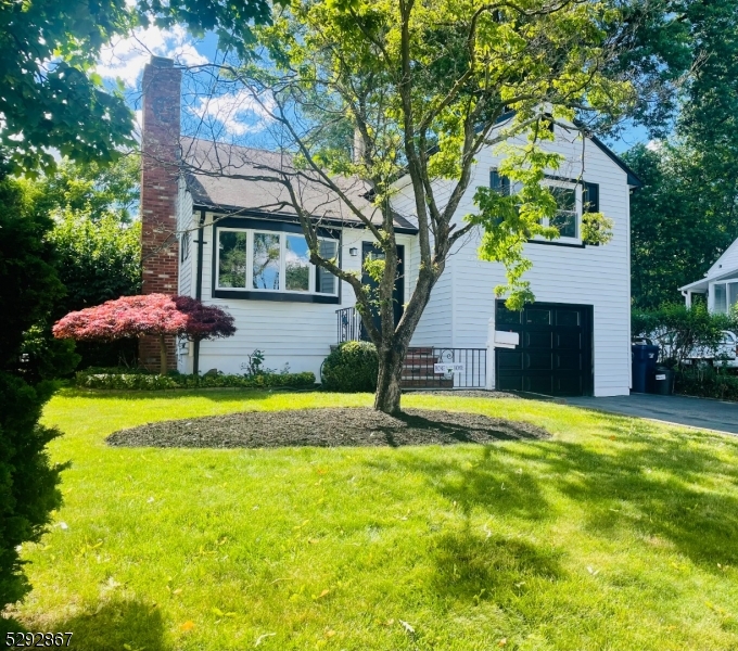 a front view of house with yard and outdoor seating