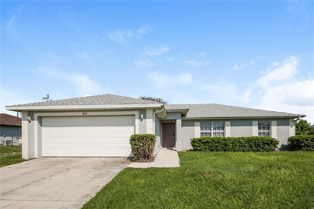 a front view of a house with a yard and garage