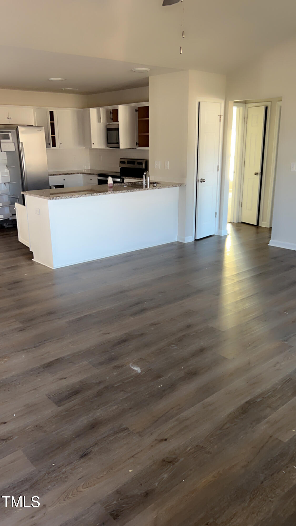 a large white kitchen with wooden floor