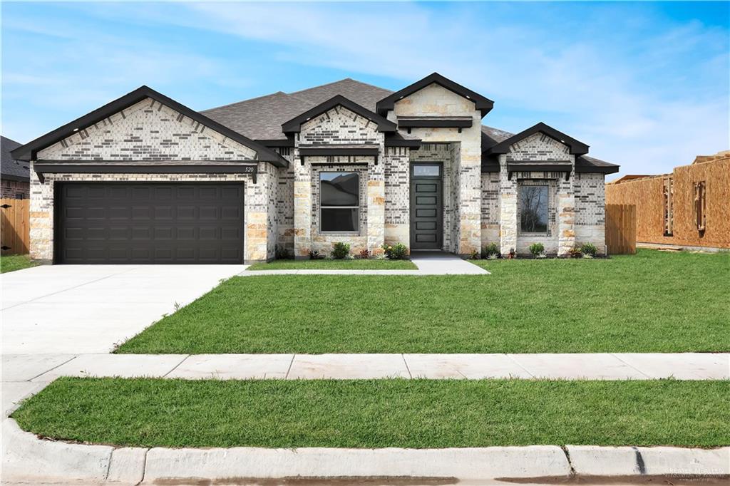 View of front facade with a front yard and a garage