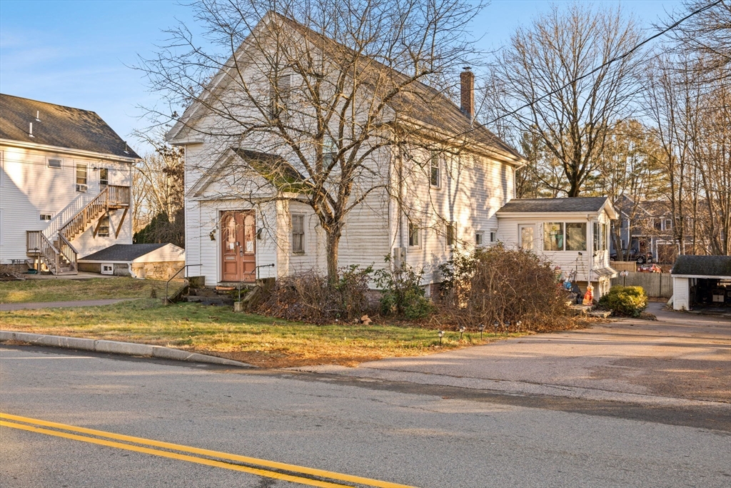 a view of a house with a yard and trees