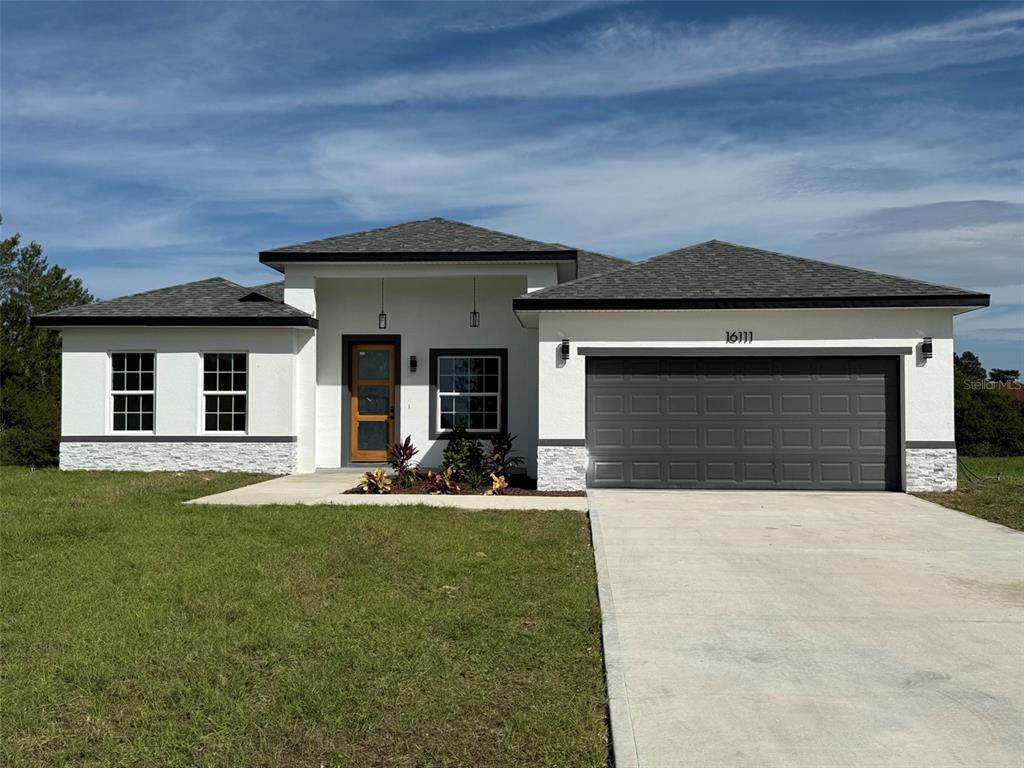 a front view of a house with a yard and garage